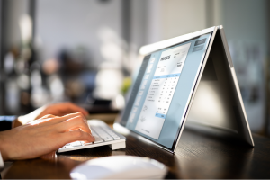 A person creating an electronic invoice on their computer.